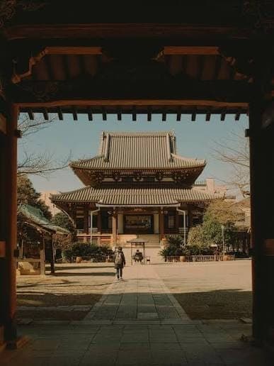 A view through a traditional Japanese gate towards a temple in Tokyo, Japan.